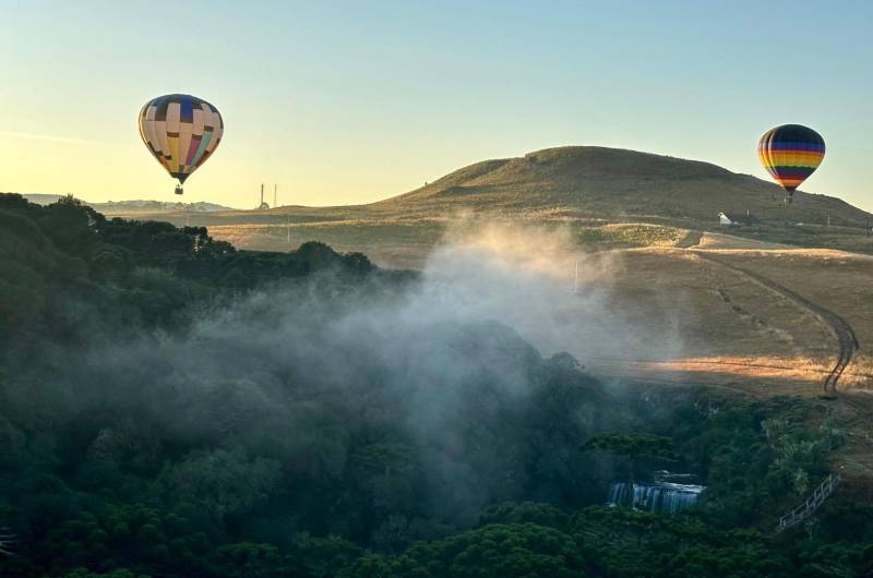 Dois balões sobrevoando o vale com névoa matinal em Cambará do Sul